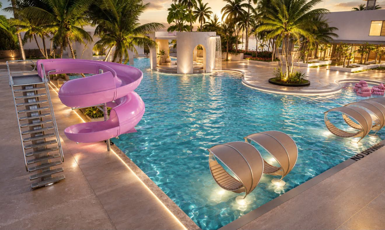 The resort pool and waterslide at sunset